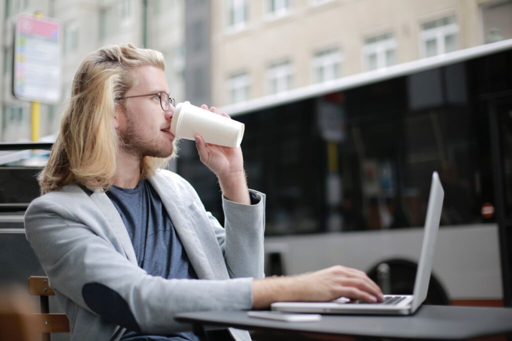 Studentă care lucrează pe laptop la un proiect pentru un client, într-o cafenea luminoasă